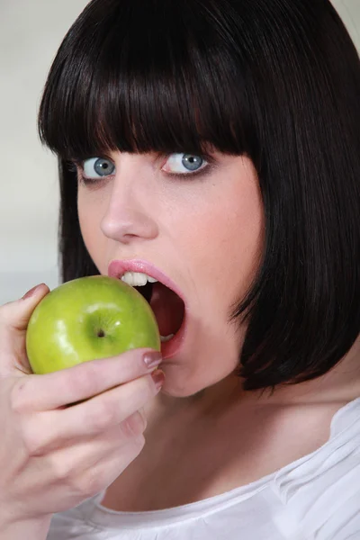 Bruna donna mordere mela — Foto Stock