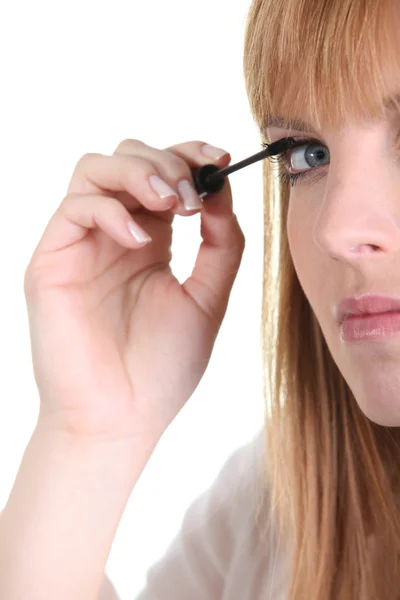 A woman putting mascara — Zdjęcie stockowe