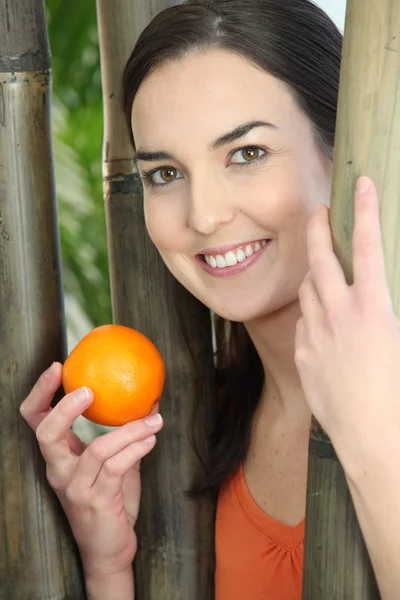 Vrouw die lacht met sinaasappel — Stockfoto