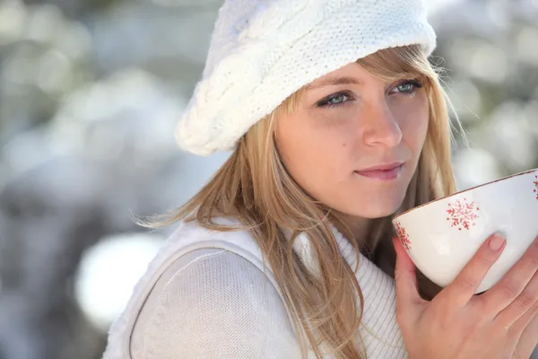 Mujer joven en la estación de esquí tomando un tazón de café — Foto de Stock