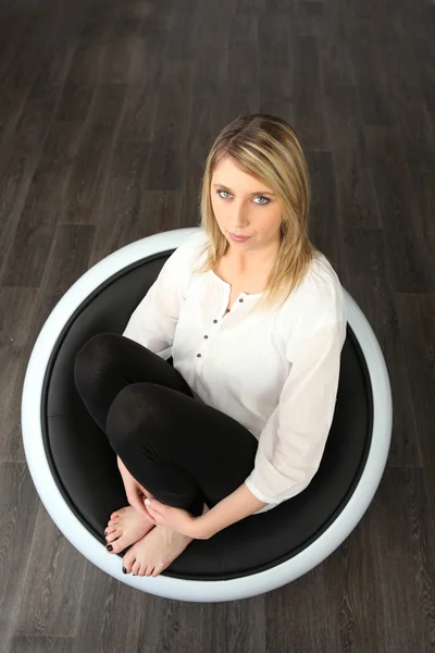 Uma mulher sentada em uma cadeira — Fotografia de Stock