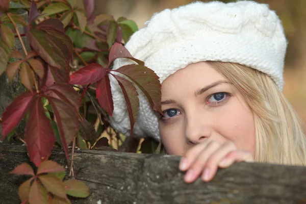 Blonde vrouw poseren door hek — Stockfoto