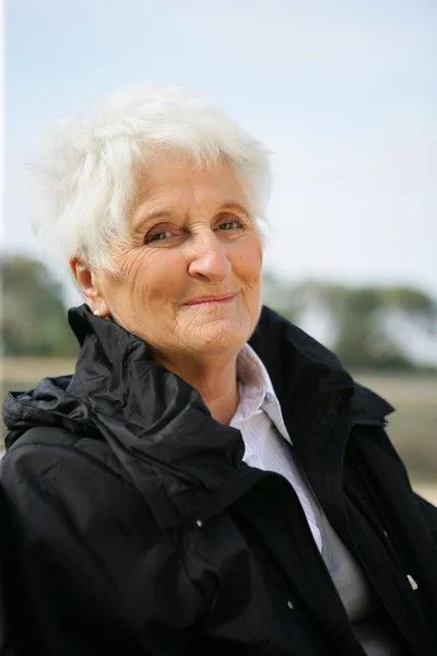 Senior lady in a black coat — Stock Photo, Image