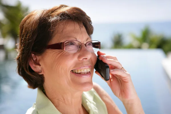 Mature woman outdoors on the phone — Stock Photo, Image