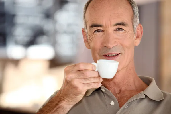 Elderly man drinking coffee — Stock Photo, Image