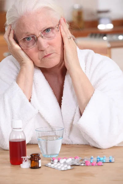 Grumpy woman taking her medication — Stock Photo, Image