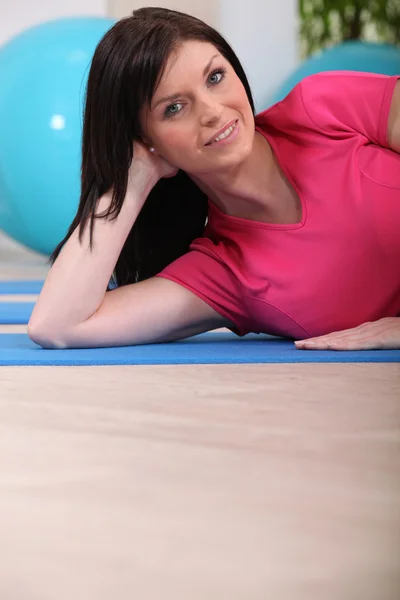 Femme posée sur tapis de gym — Photo