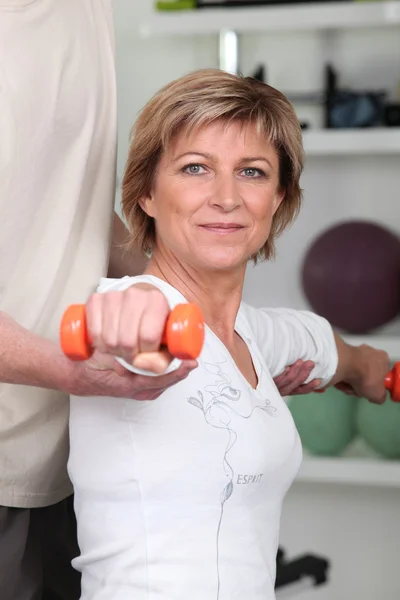 Frau trainiert mit Hilfe ihres Personal Trainers — Stockfoto