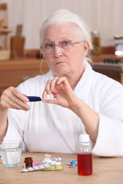 Mujer mayor tomando su medicamento Fotos de stock