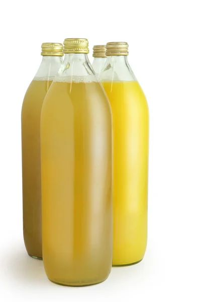 Four glass bottles of fruit juice — Stock Photo, Image