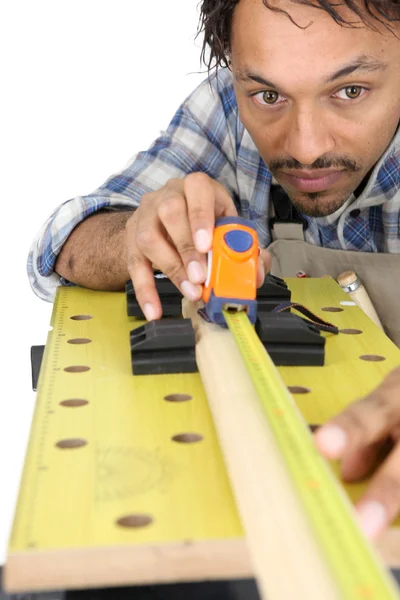 Carpinteiro medindo um pedaço de madeira — Fotografia de Stock