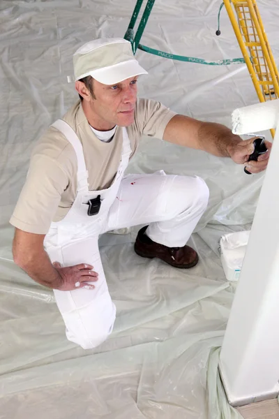 Decorador pintando una habitación blanca — Foto de Stock
