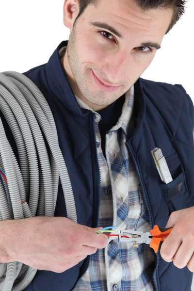 Uomo tirando fili elettrici con pinze — Foto Stock