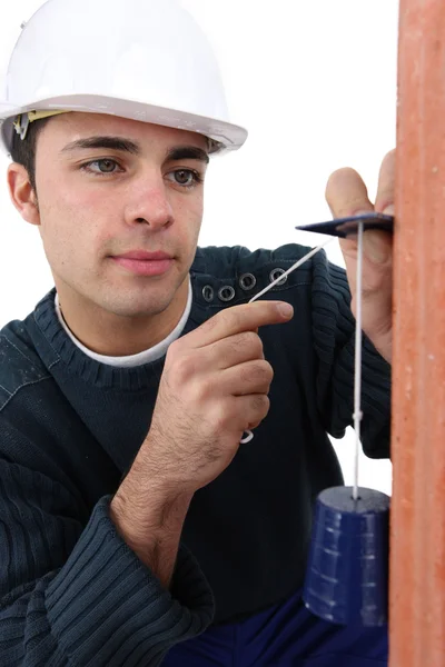Worker using a plumbline — Stock Photo, Image