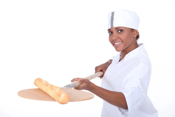Cottura di fornaio femminile una baguette — Foto Stock