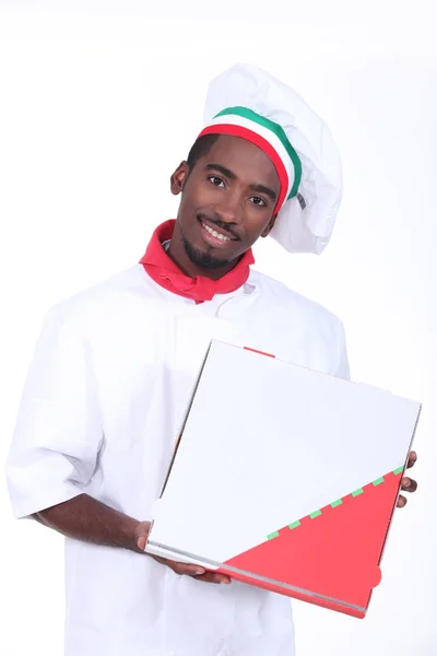 Man in a chef's outfit with a pizza box — Stock Photo, Image