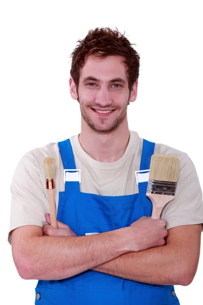 Young decorator holding two different paintbrushes — Stock Photo, Image