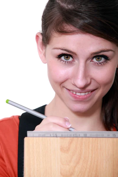 Jonge vrouwelijke schrijnwerker nemen metingen — Stockfoto