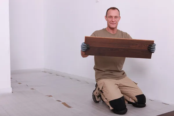 Homem que coloca piso em parquet — Fotografia de Stock