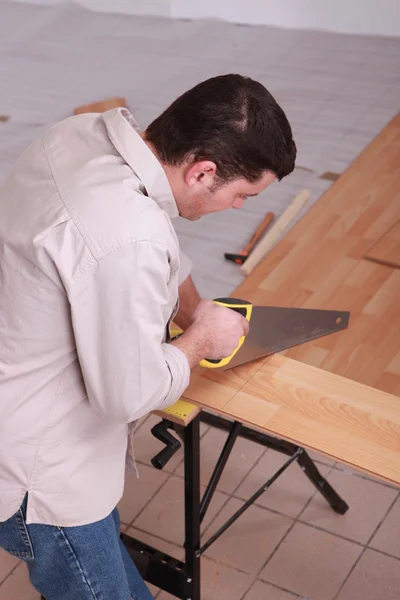 Man sawing plank of parquet — Stock Photo, Image