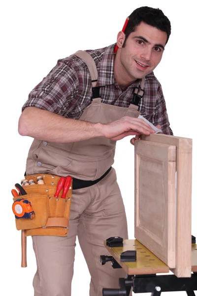 Um carpinteiro que fixa uma porta do armário . — Fotografia de Stock