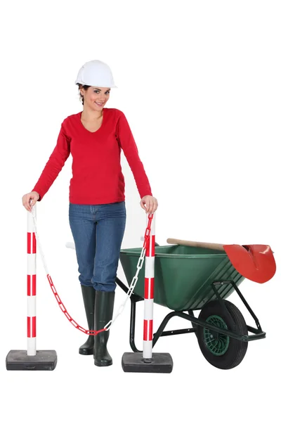 Woman worker with a wheelbarrow and barrier — Stock Photo, Image