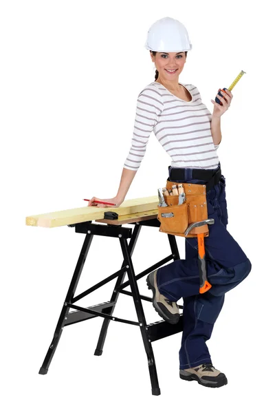 Kvinnliga byggarbetare med en arbetsbänk — Stockfoto