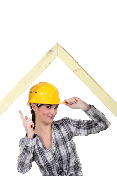 Ahşap çerçeve altında duran ve onun parmak sallayarak marangoz — Stok fotoğraf