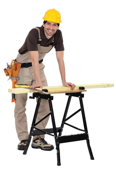 Muž řezání dřeva na stůl — Stock fotografie