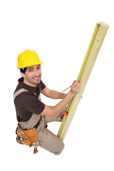 Craftsman measuring plank of wood — Stock Photo, Image