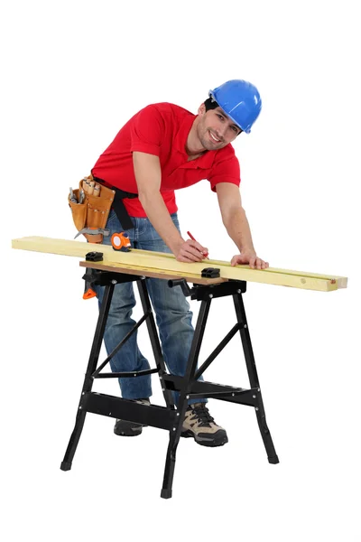 Man markering een meting op een houten plank — Stockfoto