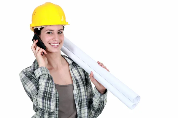 Costruttore femminile con planimetrie e telefono cellulare — Foto Stock