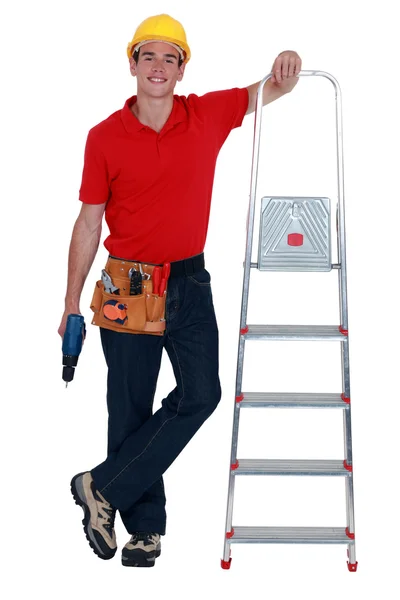 Werknemer met een trapladder en draadloze boor — Stockfoto