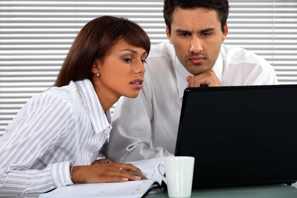 Couple d'affaires assis à un ordinateur portable — Photo