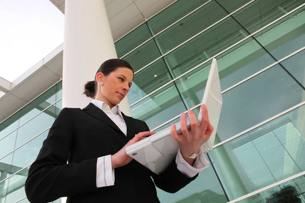 Affärskvinna med hennes laptop utanför kontoret — Stockfoto