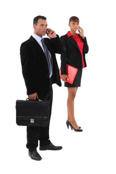 Affärsman och affärskvinna talar på deras celler — Stockfoto