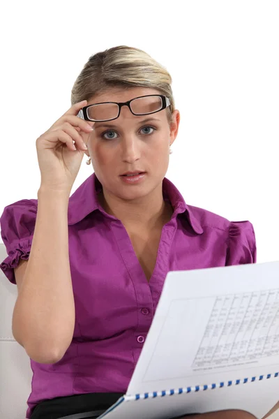 Mulher loira levantando óculos para ver melhor — Fotografia de Stock
