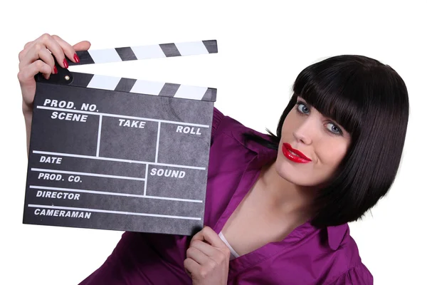 Woman holding up a clapperboard — Stock Photo, Image