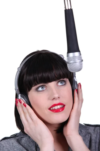 Femme chantant dans un microphone studio — Photo
