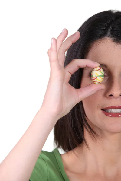 Woman covering her eye with easter egg — Stock Photo, Image