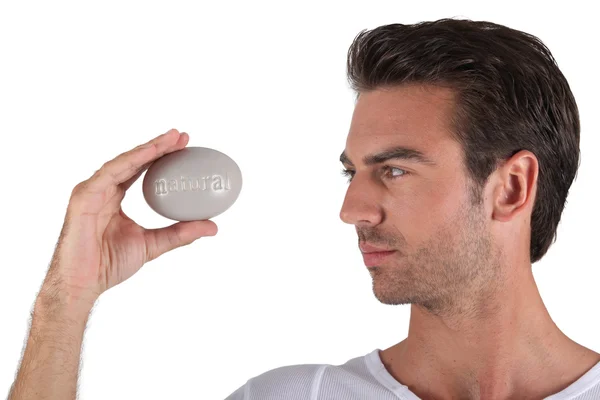 Man holding pebble in hand — Stock Photo, Image