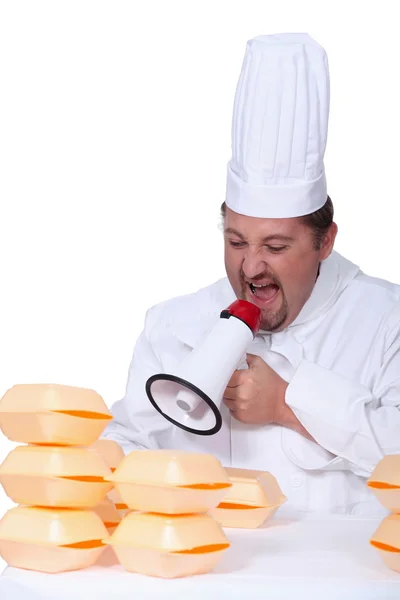 Un cuoco che urla su scatole di uova con un megafono — Foto Stock