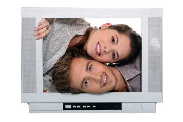 Young passing heads through TV screen — Stock Photo, Image