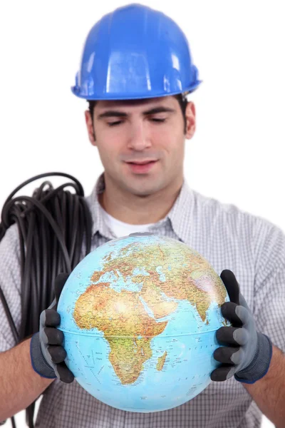 Handwerker blickt auf Globus — Stockfoto
