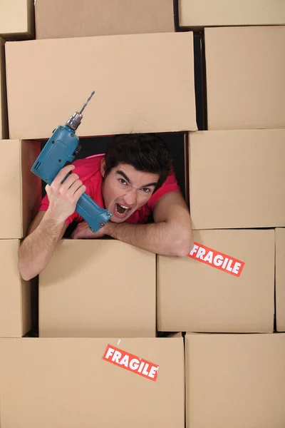Man with hole surrounded by cardboard — Stock Photo, Image