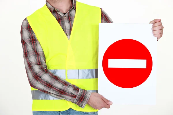 A road worker holding a wrong way sign. — Stock Photo, Image