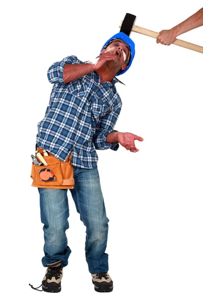 Builder being hit over head by hammer — Stock Photo, Image
