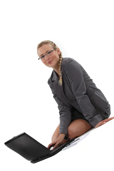Donna d'affari seduta sul pavimento e al lavoro sul suo computer portatile — Foto Stock