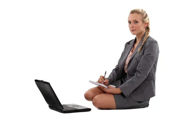 Geschäftsfrau macht sich Notizen vor ihrem Laptop — Stockfoto