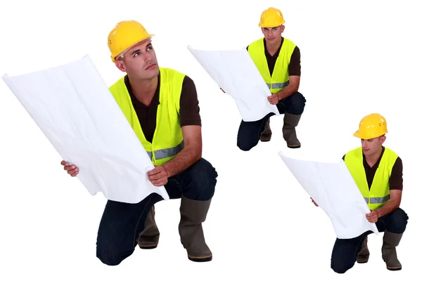 Multiple shot on foreman with plans kneeling — Stock Photo, Image